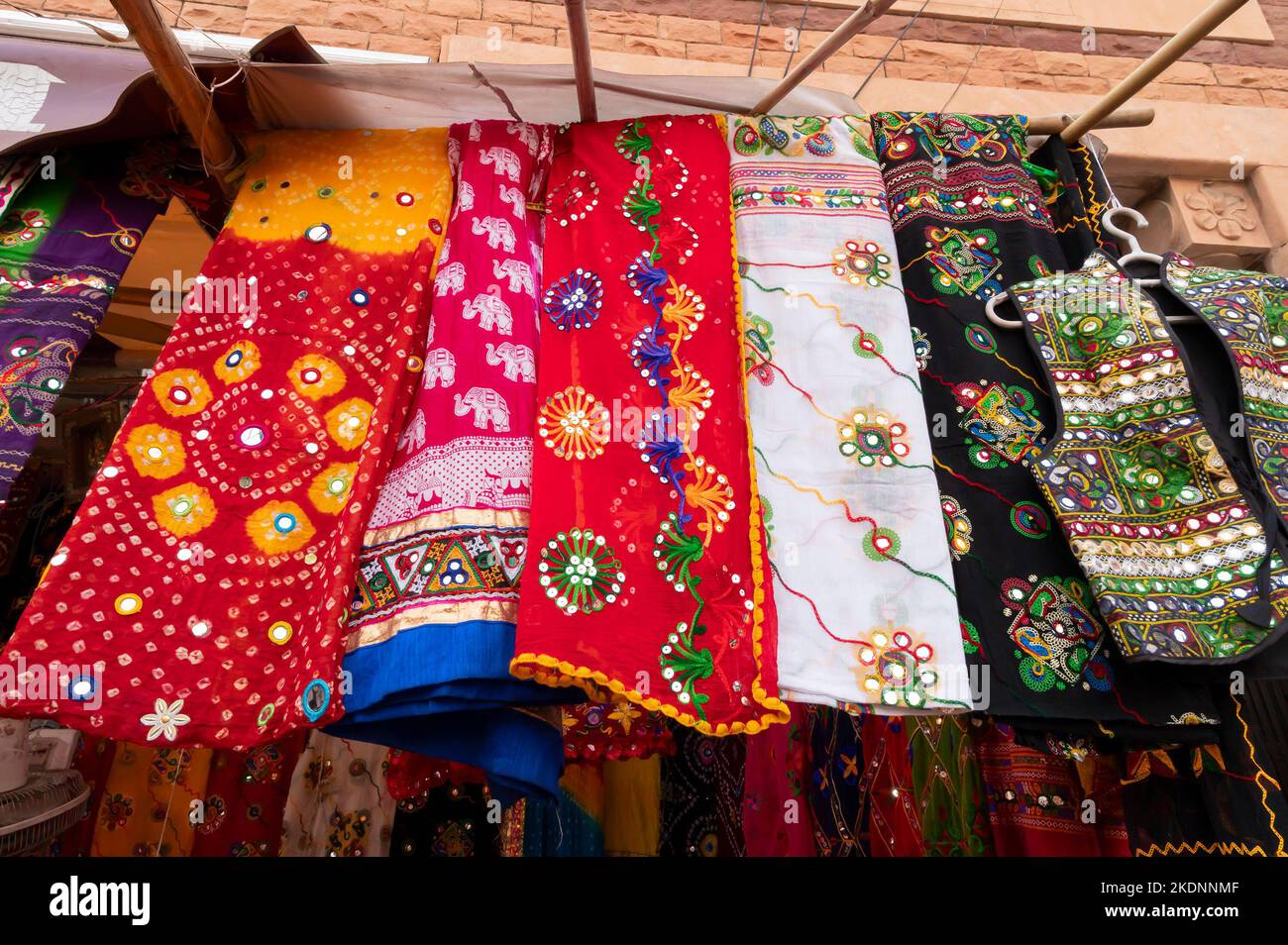 Rajasthani Frauenkleidung hängen zum Verkauf , wird in einem Geschäft auf dem berühmten Sardar Markt und Ghanta ghar Uhrenturm am Abend angezeigt. Stockfoto