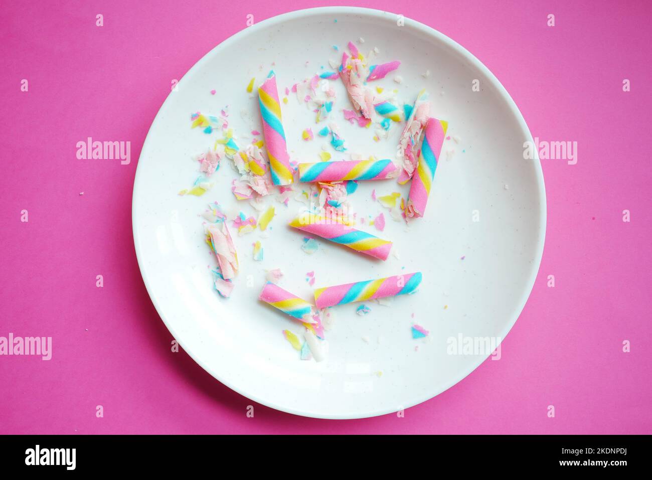 Bunte Waferrolle Schokolade auf rosa Hintergrund Stockfoto