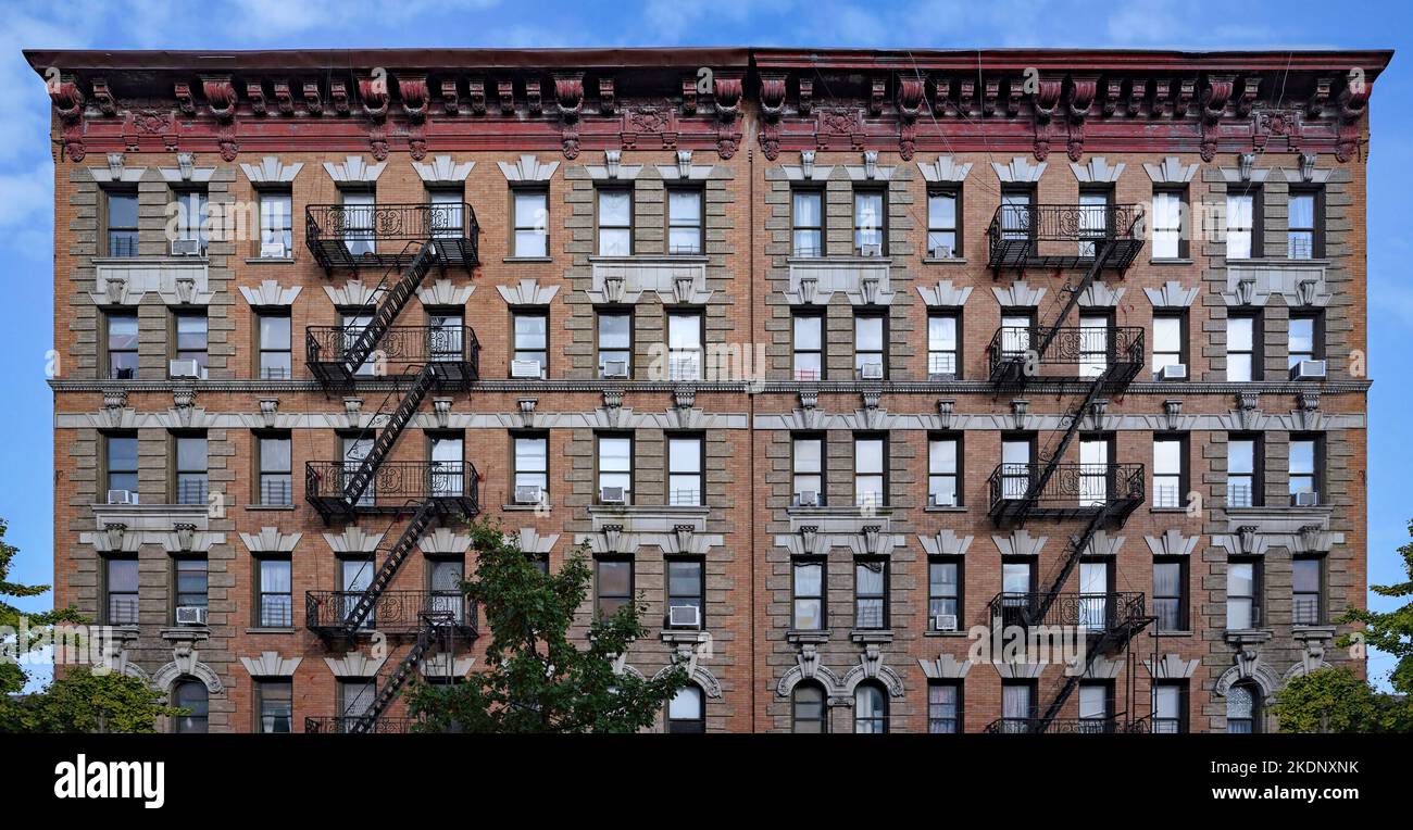 Altmodisches New York City-Apartmentgebäude mit dekorativer Dachzierleiste und externen Feuerlöschern Stockfoto