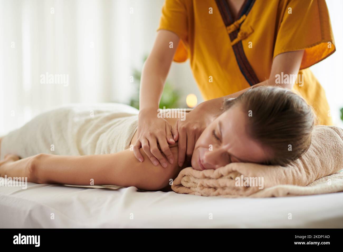 Frau mittleren Alters bekommt eine entspannende Rückenmassage im Spa-Salon Stockfoto