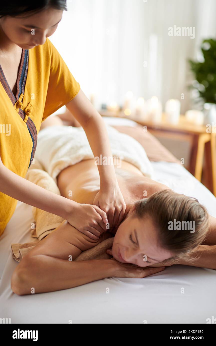 Reife Frau bekommt Schultern und Rückenmassage mit Ölen im Spa Salon Stockfoto