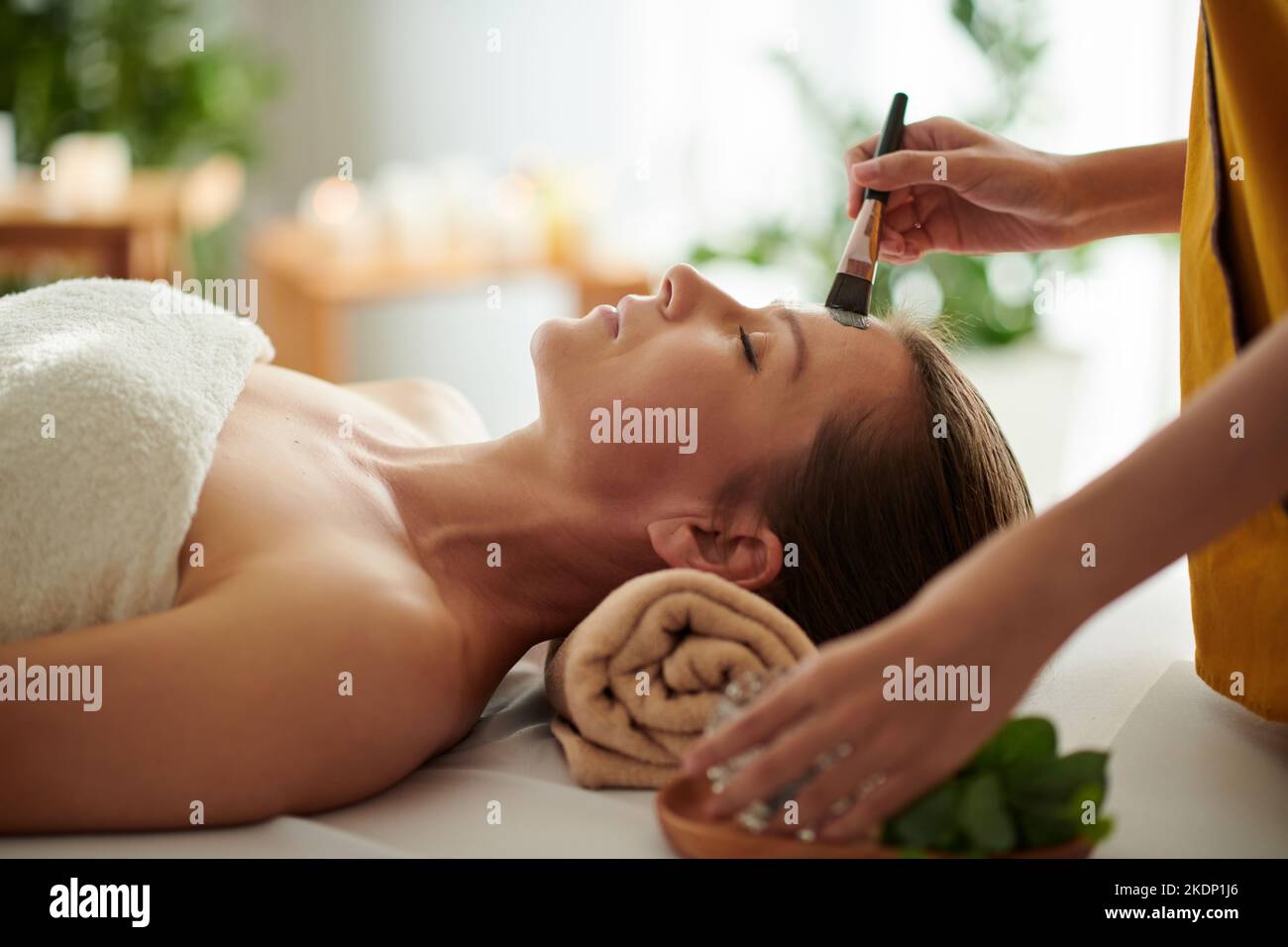 Reife Frau bekommen Spa Verfahren einschließlich Tonmaske im Schönheitssalon Stockfoto