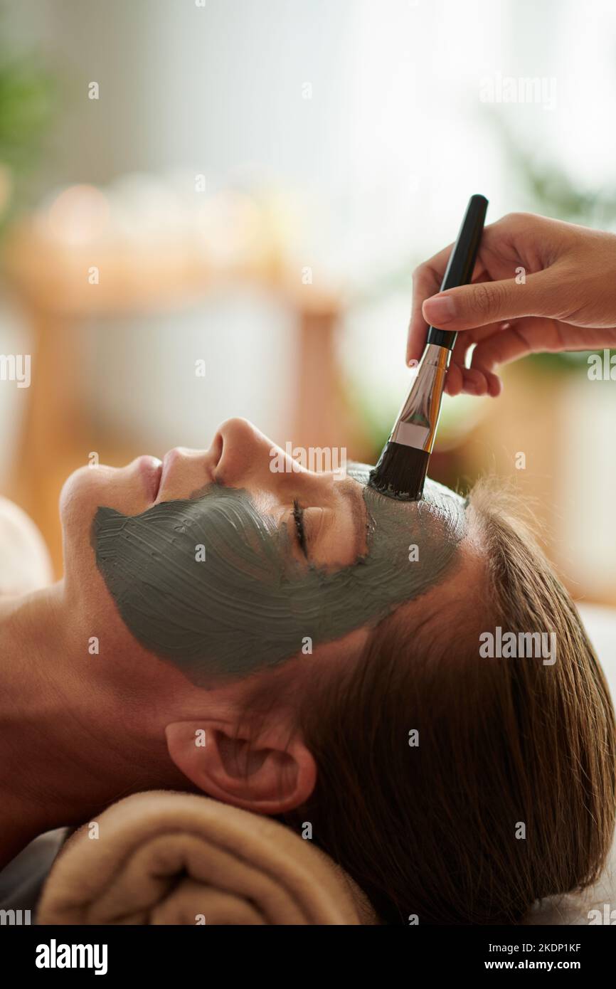 Reife Frau bekommen Tonmaske Spa-Behandlung im Schönheitssalon Stockfoto