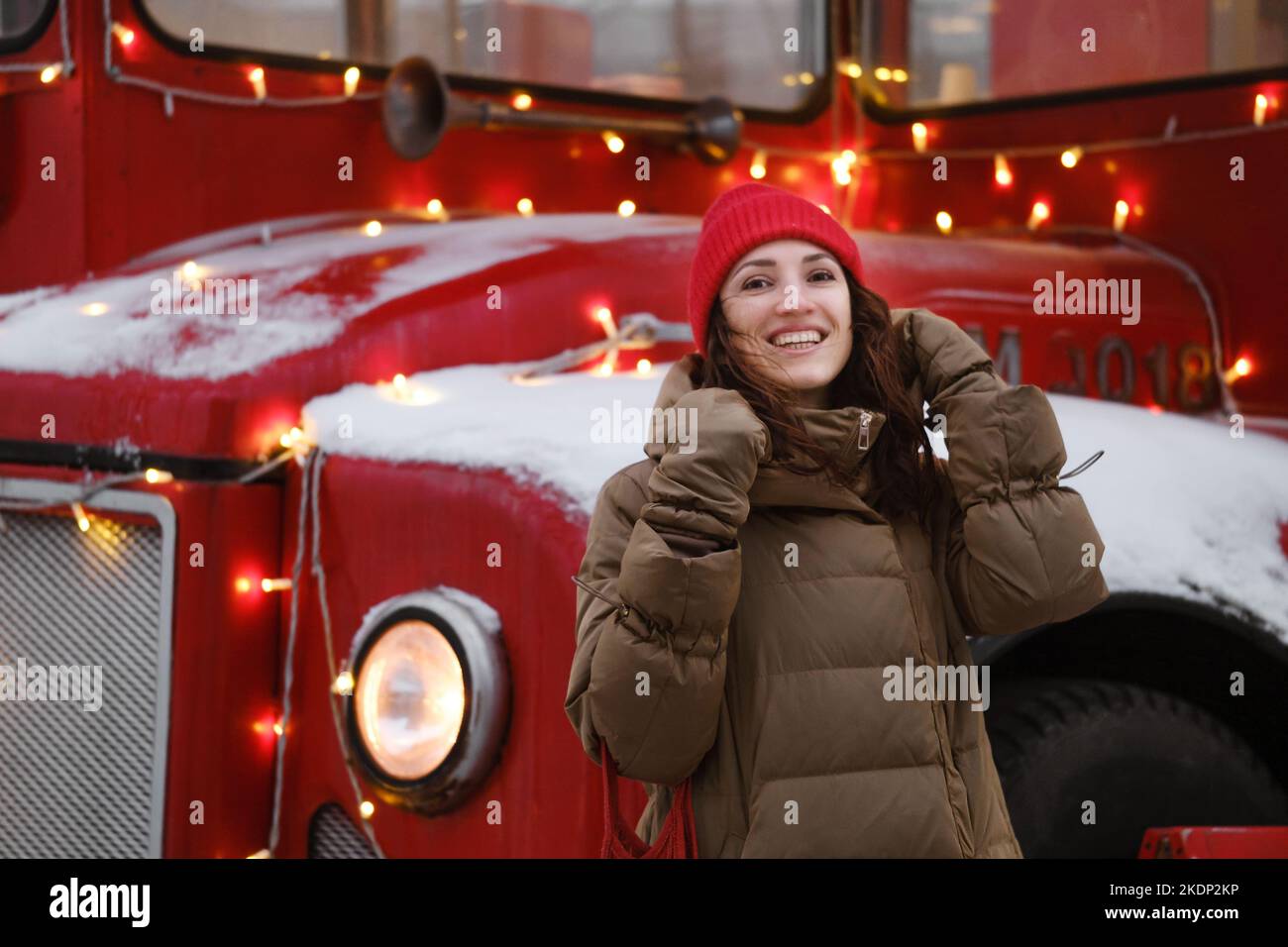 Glückliche Frau in der Nähe von London Doppeldecker rot alten Bus im Winter lächelnd, genießen Sie Schnee. Weihnachtsstimmung Urlaubscafé Stockfoto