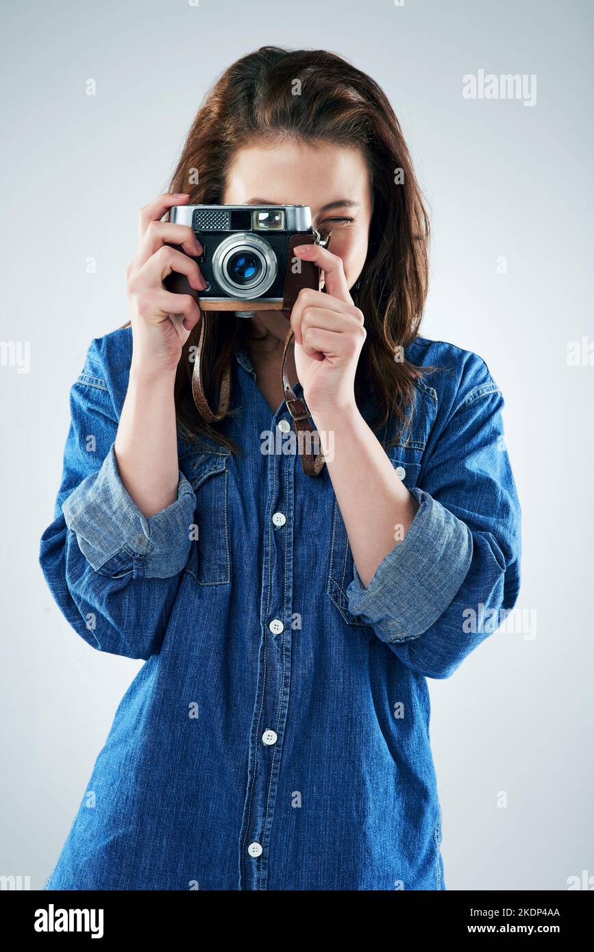 Können Sie Käse sagen, bitte. Studioportrait einer jungen Frau mit einer Vintage-Kamera vor grauem Hintergrund. Stockfoto Können Sie Käse sagen, bitte. Studioportrait einer jungen Frau mit einer Vintage-Kamera vor grauem Hintergrund. Stockfoto