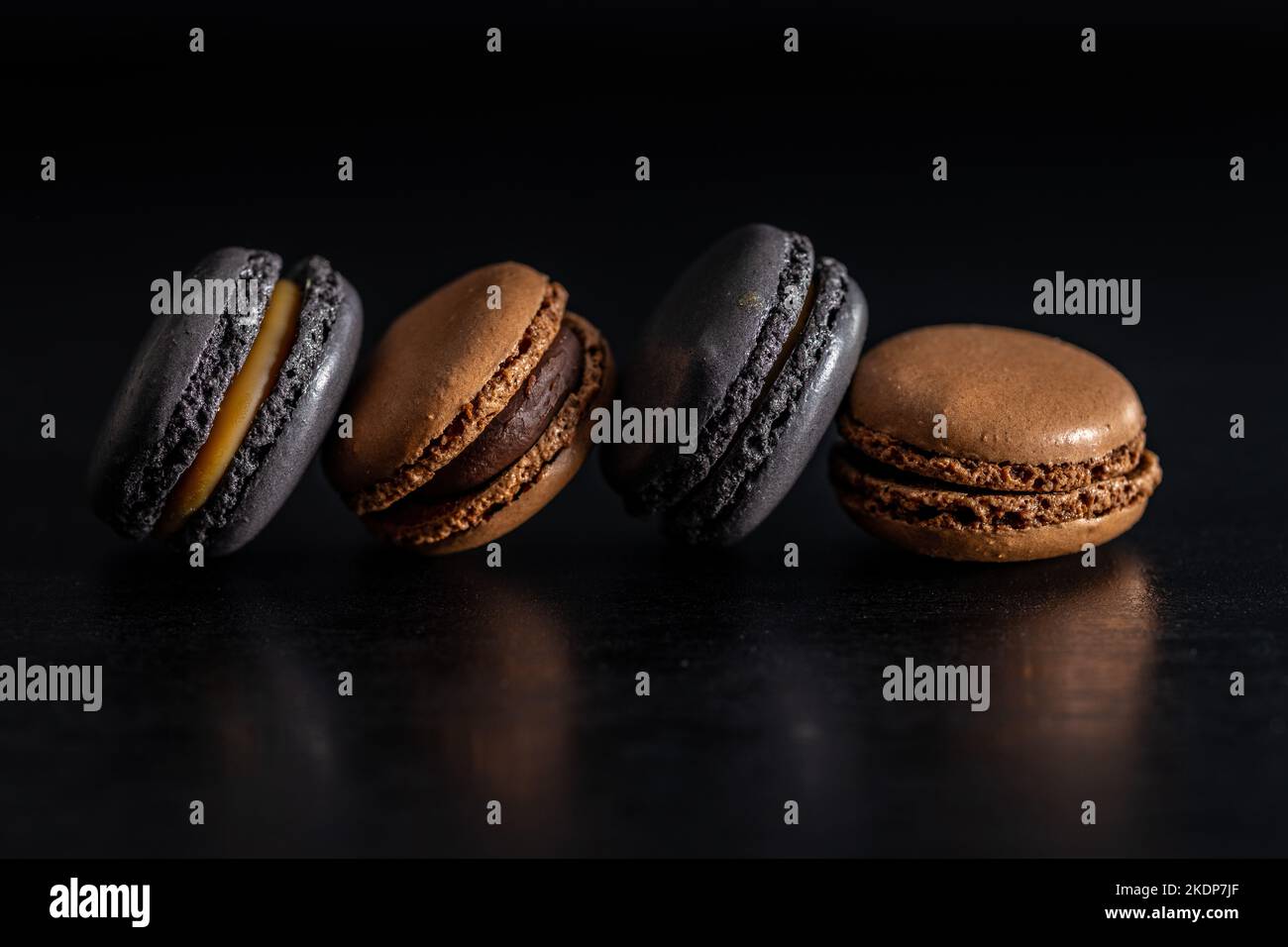 Süßes Makronen-Dessert auf dem schwarzen Tisch. Stockfoto