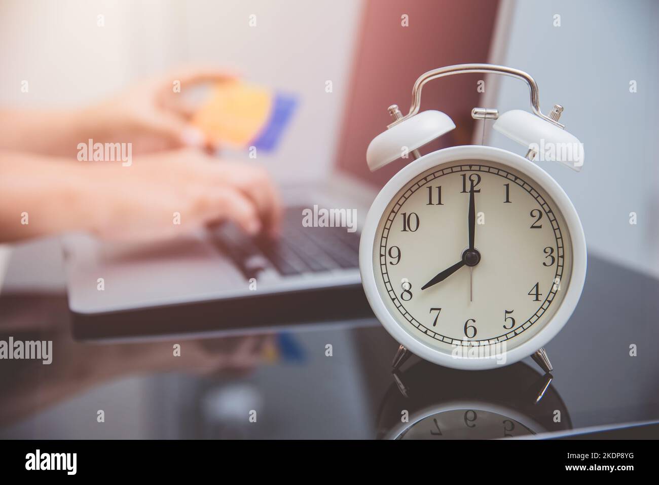 Handeingabe Kreditkartennummer mit Zeituhr für Online-Shopping-Zeiten Konzept Stockfoto