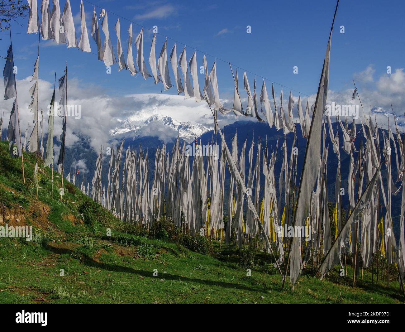 Wunderschöne Berglandschaft mit schneebedeckter Kangchendzönga Range, die durch buddhistische Gebetsfahnen und Banner in Pelling, Sikkim, Indien, gesehen wird Stockfoto
