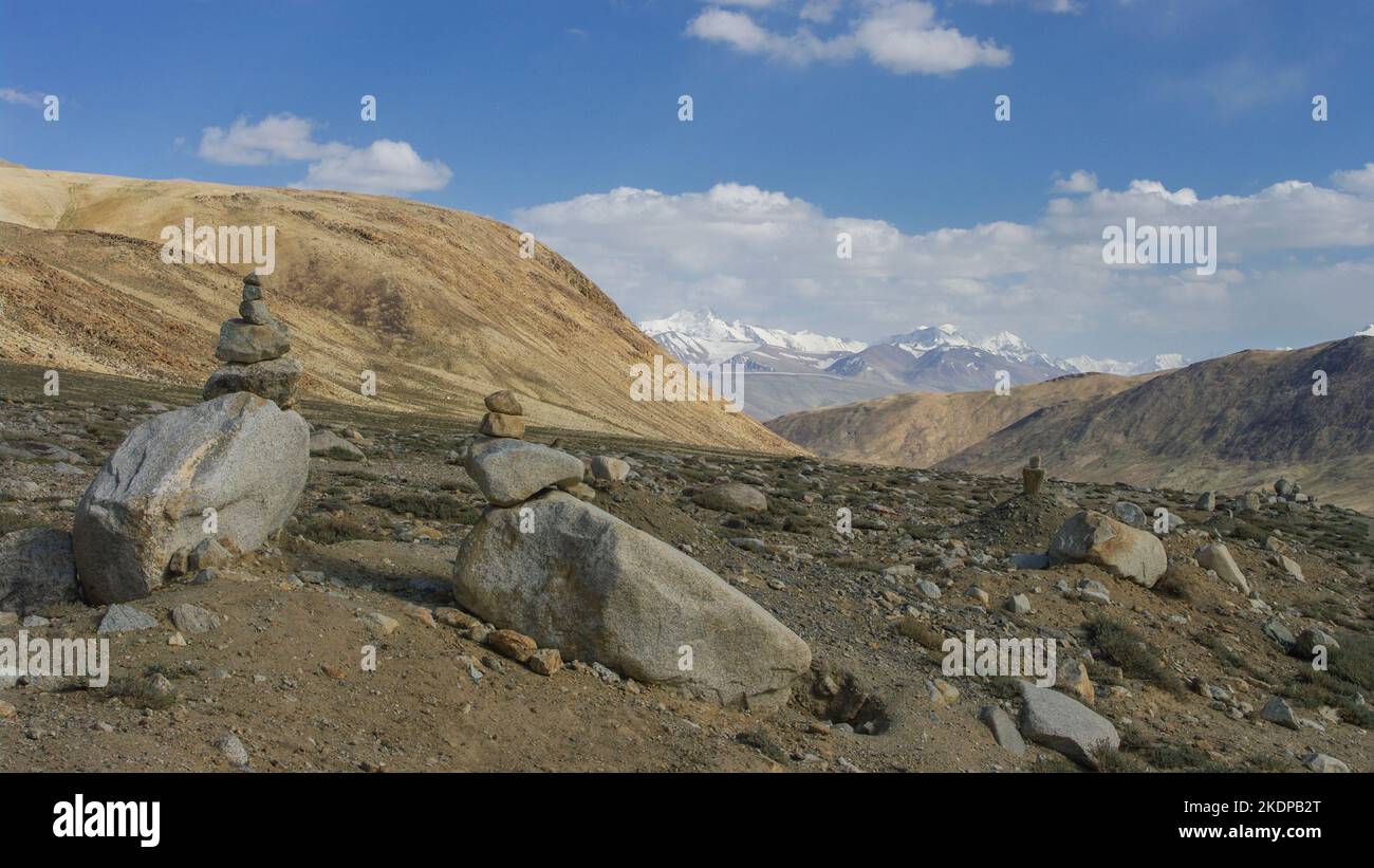 Landschaftlich reizvoller Blick auf schneebedeckte Berge mit cairns im Vordergrund am hochgelegenen Khargusch-Pass in Gorno-Badakshan, Tajikistan Pamir Stockfoto