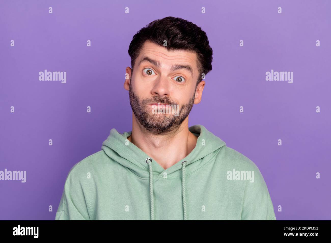 Nahaufnahme Foto von jungen lustig unglücklich verärgert Mann tragen khaki Kapuzenpullover Lippen nicht wissen unzufrieden seine neue Frisur auf violette Farbe isoliert Stockfoto