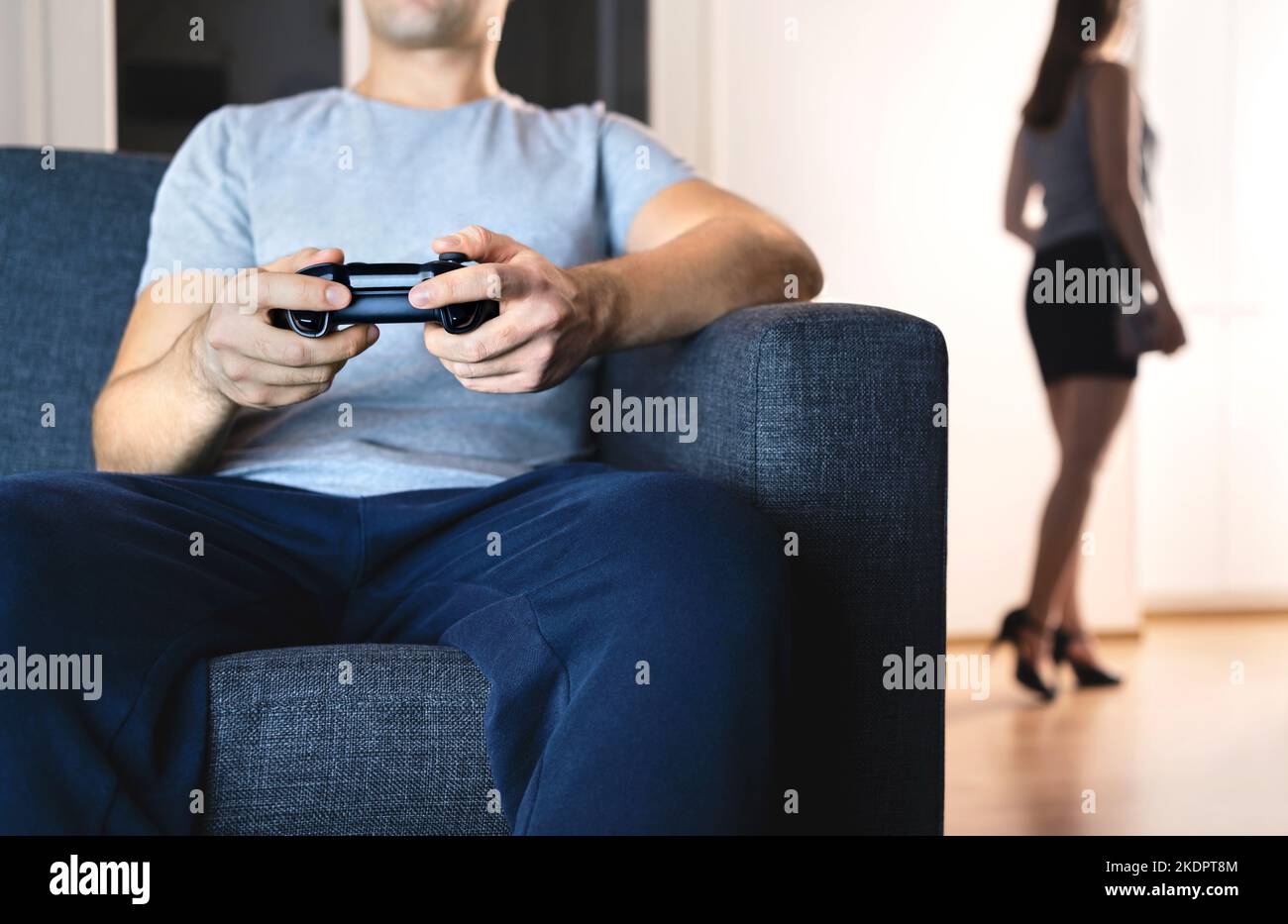 Ehepaar in ferner Ehe. Mann spielt Videospiel ignoriert Frau. Fehlende Verbindung. Beziehungskampf und Krise. Fauler Mann auf der Couch. Stockfoto