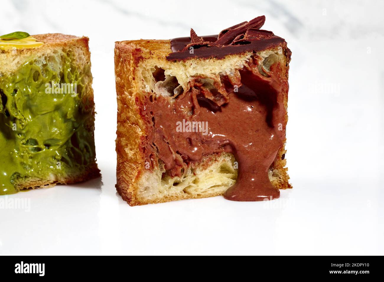 In Scheiben geschnittene, würfelförmige Croissants aus Blätterteig mit Pistazien-Pudding und Schokoladencreme Stockfoto