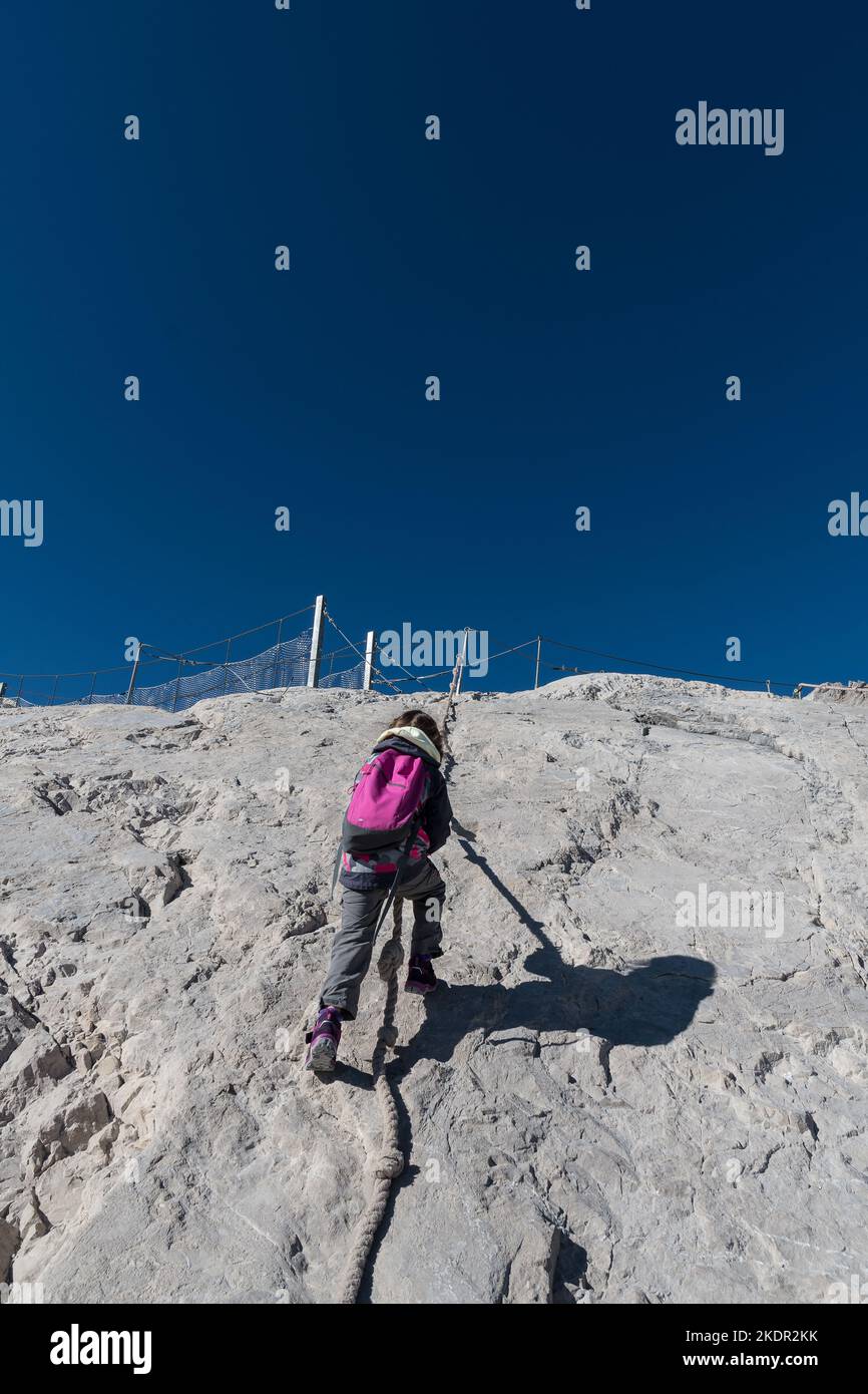 Junges Mädchen klettert in den Bergen. Rückansicht. Stockfoto