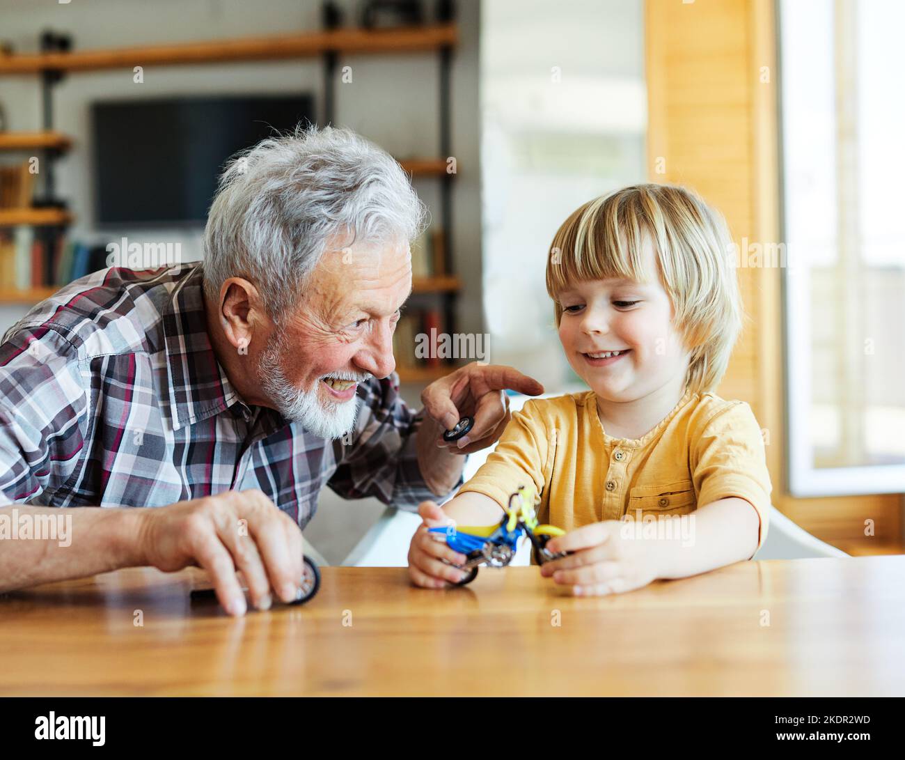 Enkelkind Familie Kind Großeltern Großvater Bildung Spielzeug Junge Spaß zusammen Senior Kind Enkel glücklich zu Hause umarmt Bindung Ruhestand Stockfoto