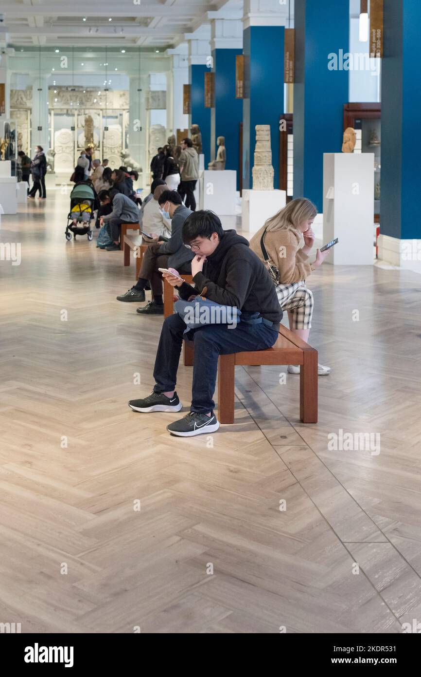 Touristen, die ihre Handys in einem Museum betrachten Stockfoto