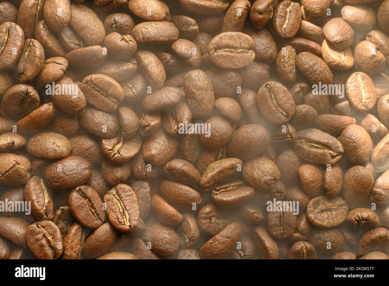 Textur von frisch geröstetem, trinkfertiger Kaffee, Dampf über Bohnen, schwarze ava-Bohnen, selektiver Fokus- und Kopierbereich. Stockfoto