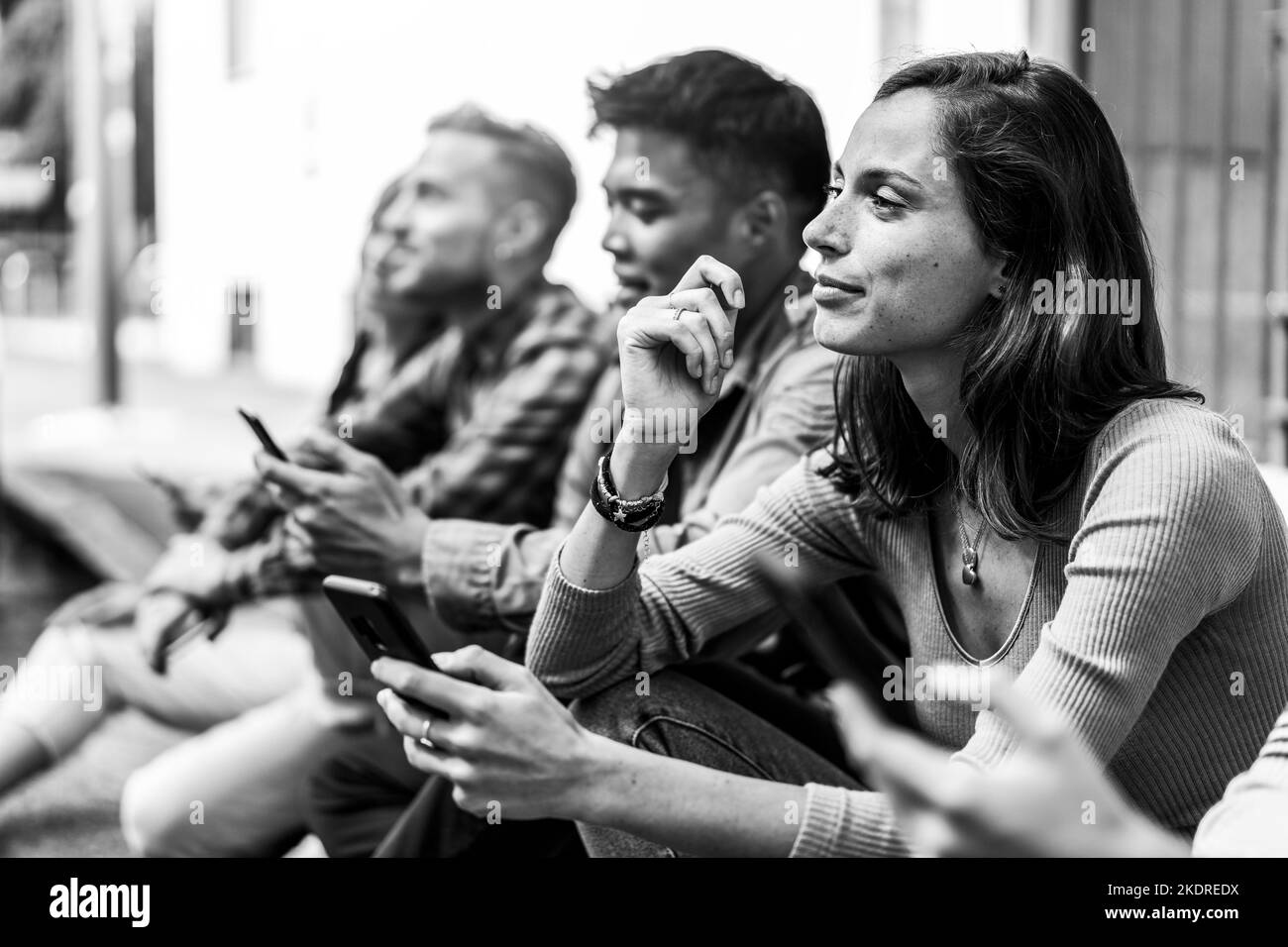 Nachdenkliche Freunde Gruppe mit Smartphone sitzen an der Universität College Hinterhof - Junge Menschen süchtig nach Handy - Technologie trauriges Leben Konz Stockfoto