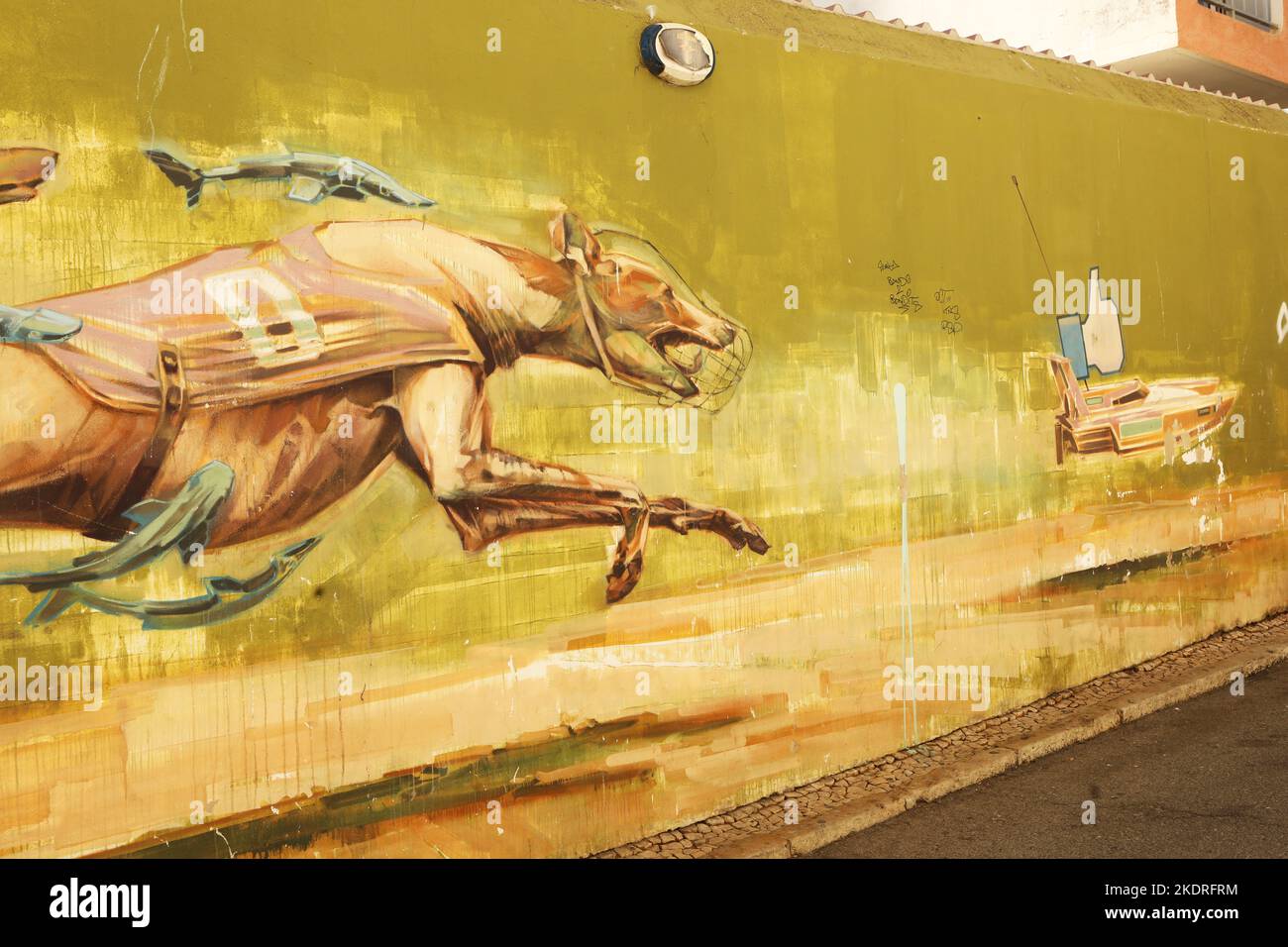 Ein Wandbild von zwei Windhunden und einem Adler, der ein Motorboot auf einer Mauer in der Altstadt von Lagos, Algarve, Portugal jagt Stockfoto