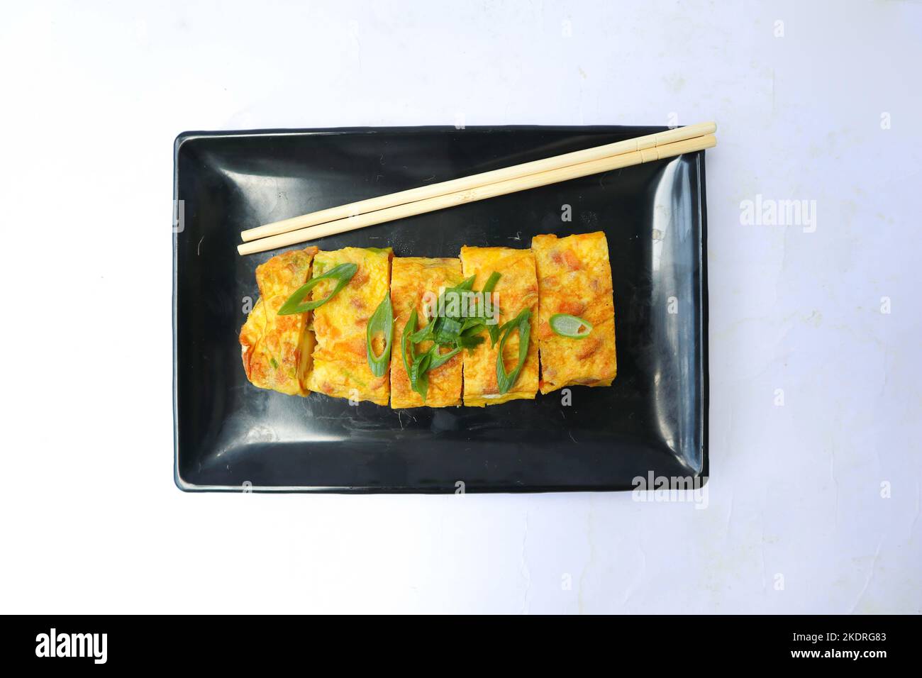 Telur dadar Gulung oder Tamagoyaki oder japanisches Eierlikel. Gyeran Mari oder koreanische gerollte Omelette. Spiegelei isolieren weißen Hintergrund Stockfoto
