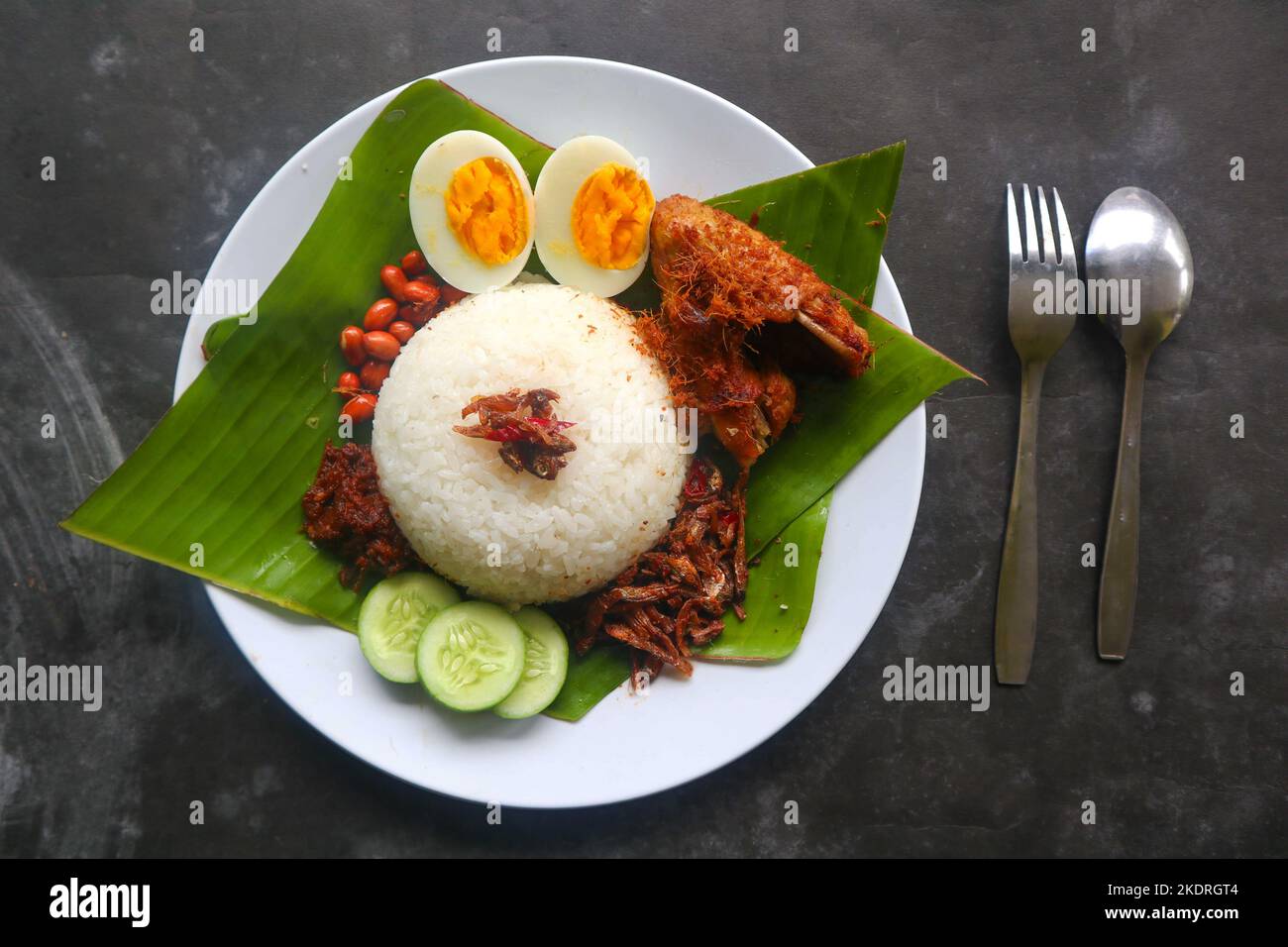 nasi Lemak, ist traditionell malaiisch gekochte Eier, Bohnen, Sardellen, Chili-Sauce, Gurke. Aus Gericht auf einem Bananenblatt serviert Stockfoto