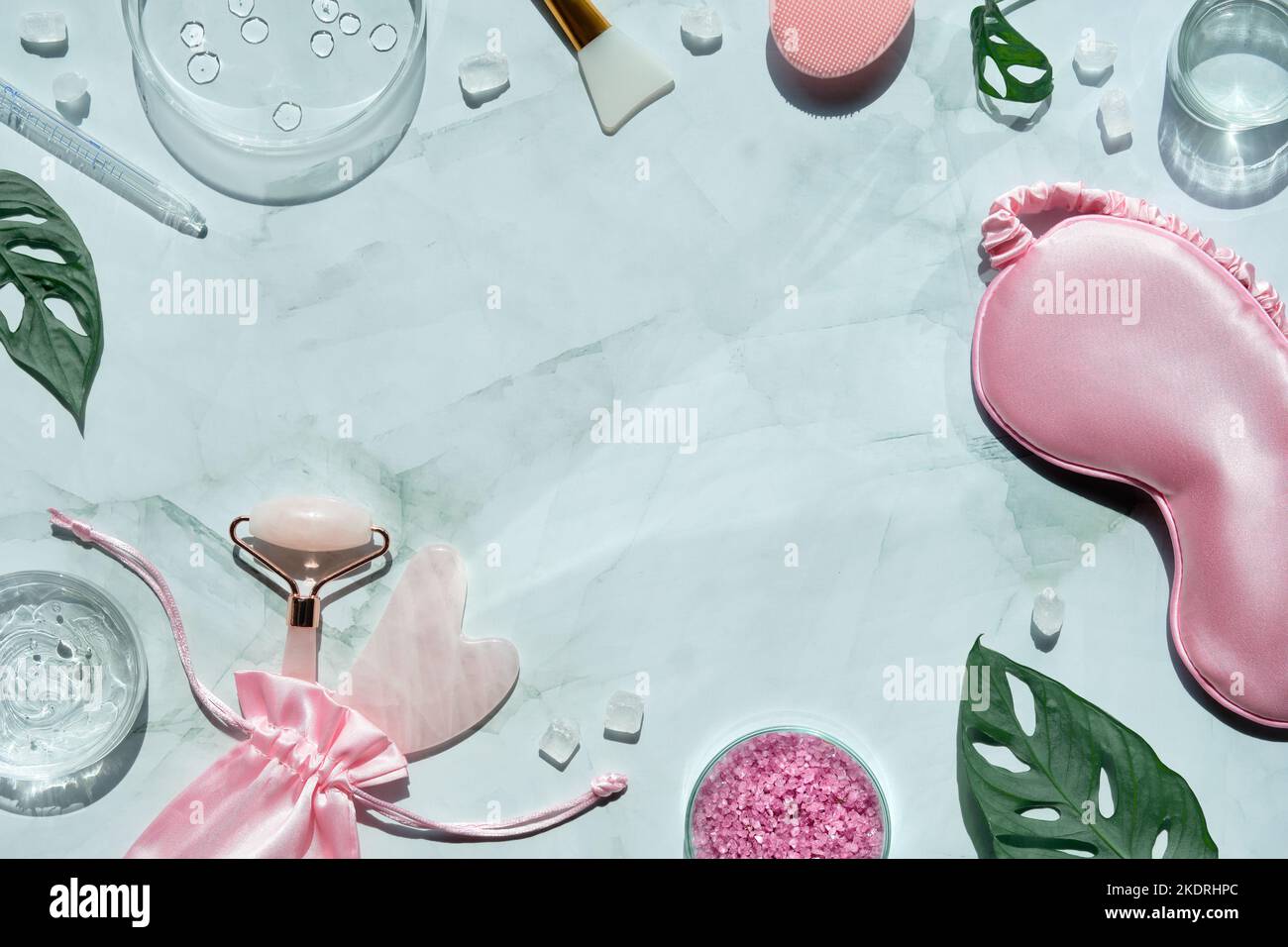 Gesichtswalze aus rosa Stein. Anti-Age-Gesichtsmassage für natürliche Lifting-Behandlung. Wellness Draufsicht auf Minzgrün mit Monsterablättern. Handtuch, schlafen Stockfoto