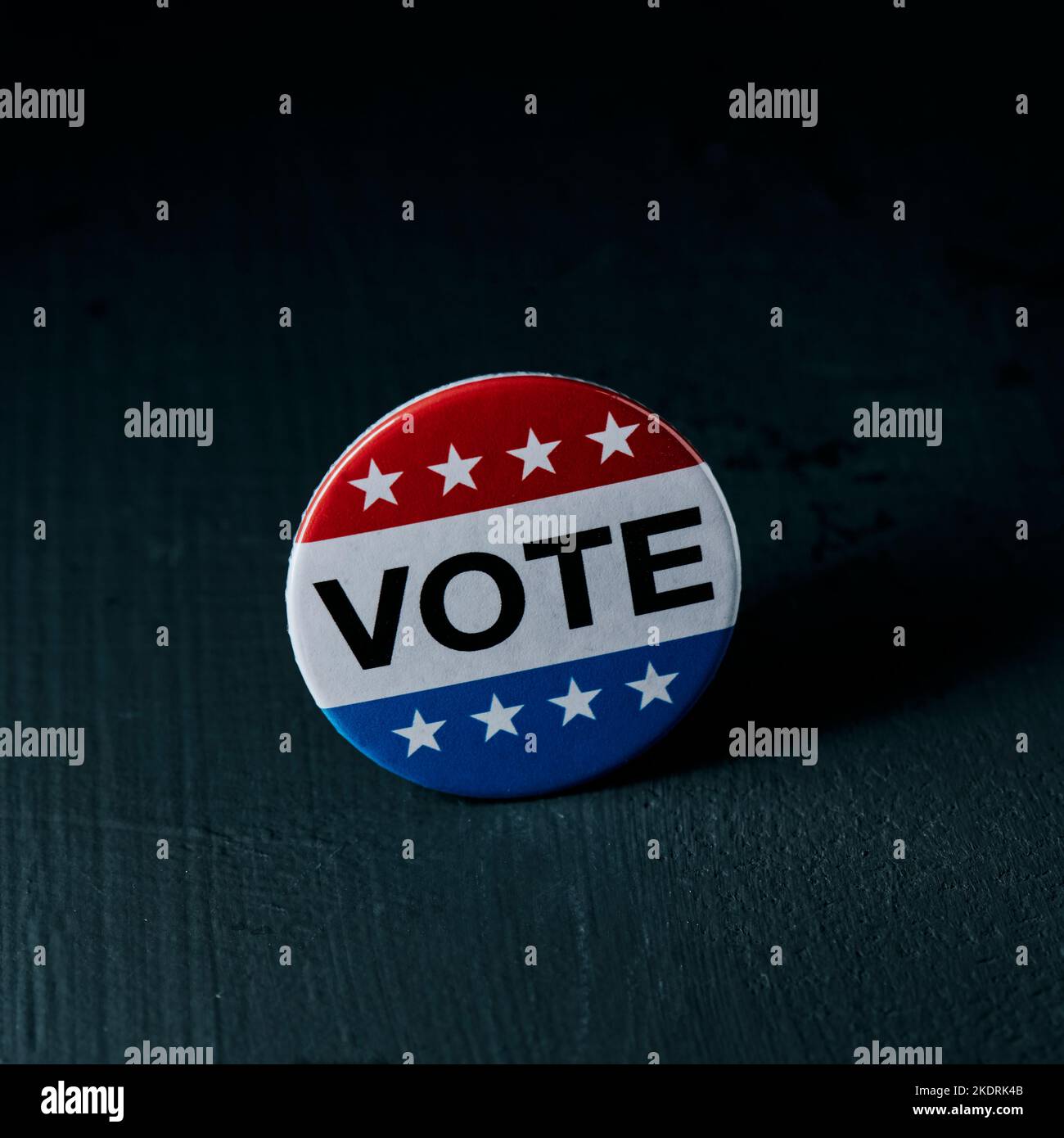 Ein Abzeichen für die Wahl in den Vereinigten Staaten, in dem der Text der Abstimmung steht, auf einer dunkelgrauen Oberfläche in einem quadratischen Format platziert Stockfoto