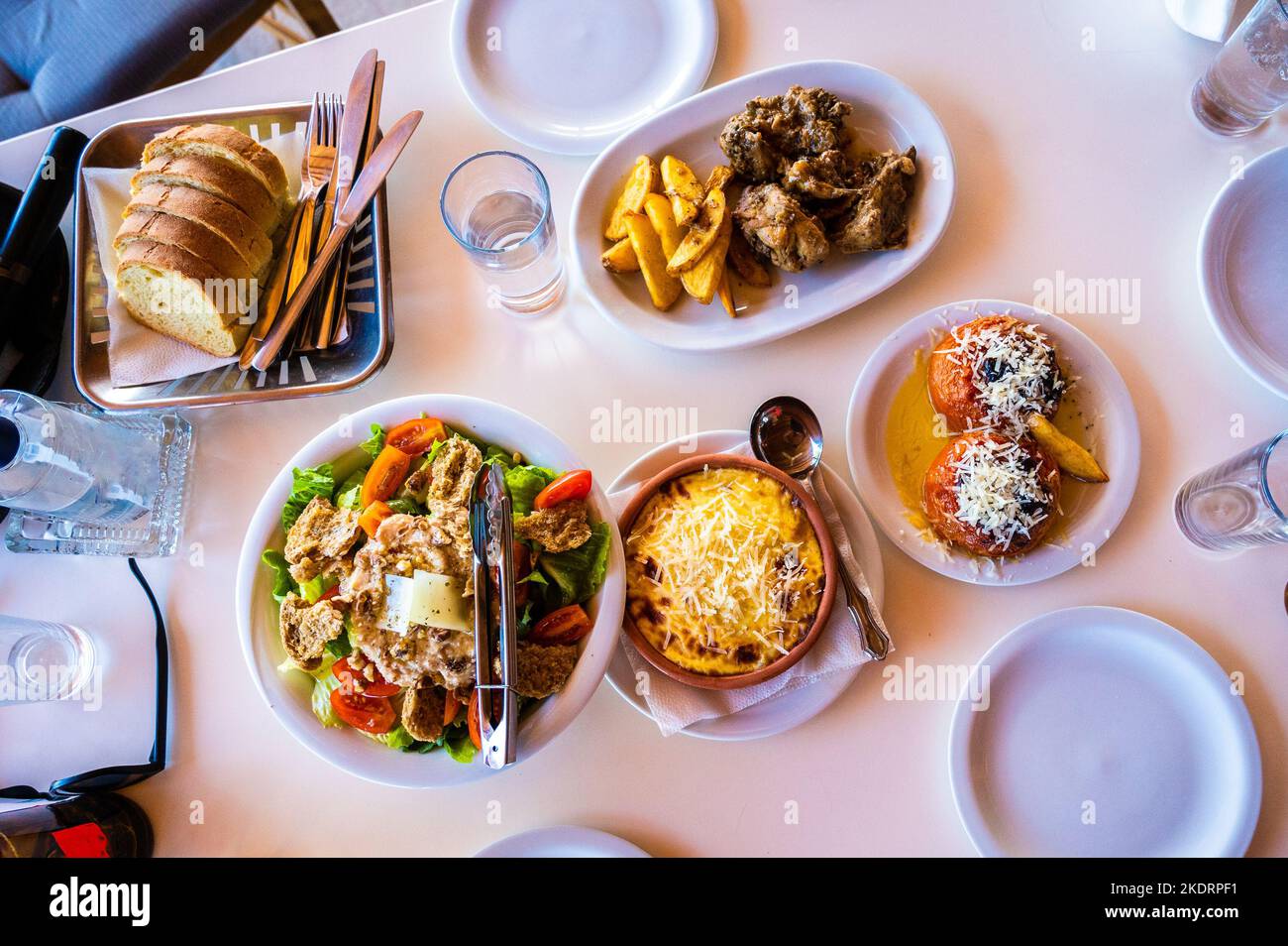 Familie essen traditionelle griechische Küche in Restaurant Taverne in Griechenland. Traditionell werden griechische Gerichte in einer griechischen Taverne auf authentischen Abendtischen serviert und Stockfoto