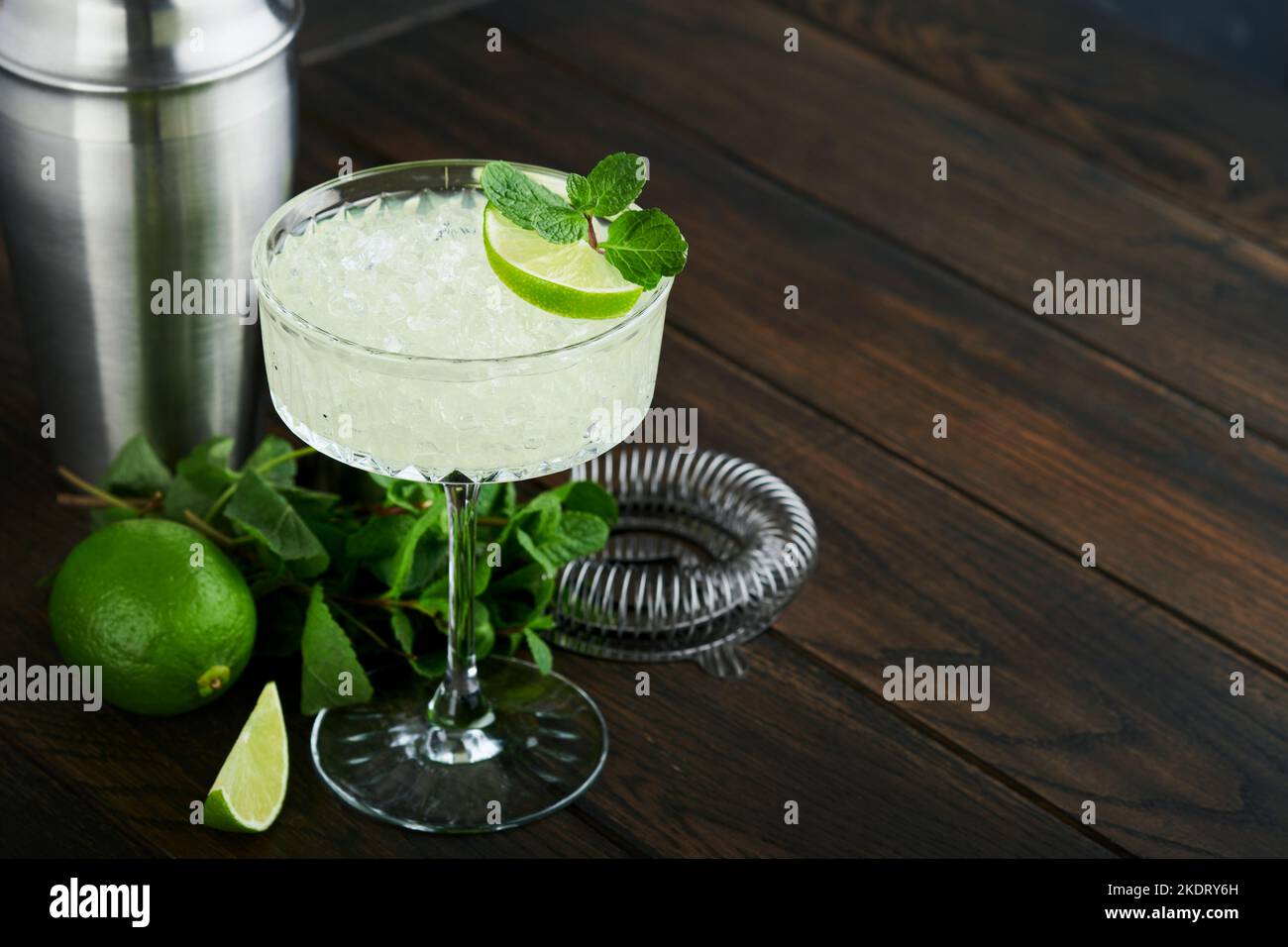 Margarita Cocktail mit Limette, Tequila, Minze und Eis auf dunklem Tisch mit erstaunlicher Hintergrundbeleuchtung, Kopierraum. Klassischer Margarita- oder Daiquiry-Cocktail. Barkarte Stockfoto