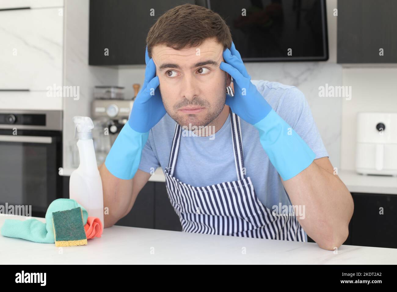 Überarbeiteter, aussehender Mann, der die Küche putzte Stockfoto