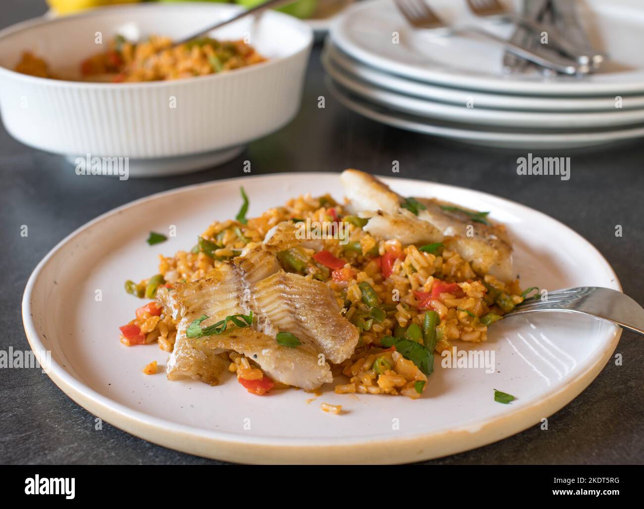 Fisch mit braunem Gemüse-Reis auf einem Esstisch Stockfoto