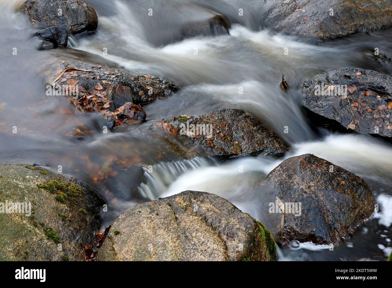 Wasser fließt in Zeitlupe in Stromschnellen über Felsen Stockfoto