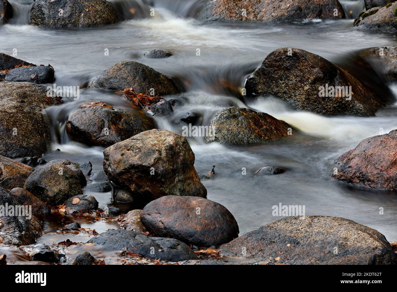 Wasser fließt in Zeitlupe in Stromschnellen über Felsen Stockfoto