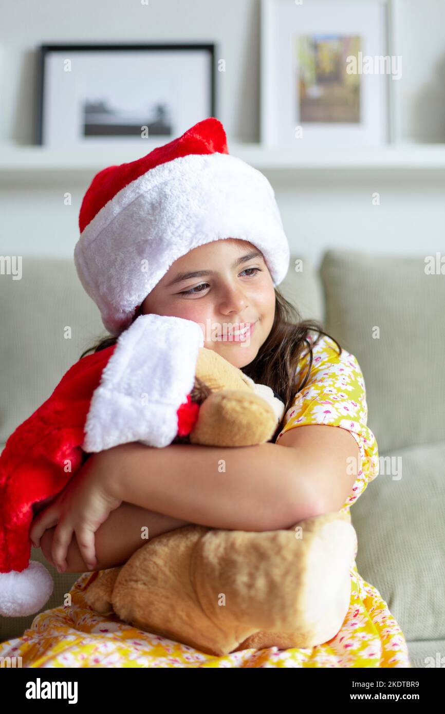 Kaukasisches kleines Mädchen umarmt Teddybär. Weihnachtszeit zu Hause. Stockfoto