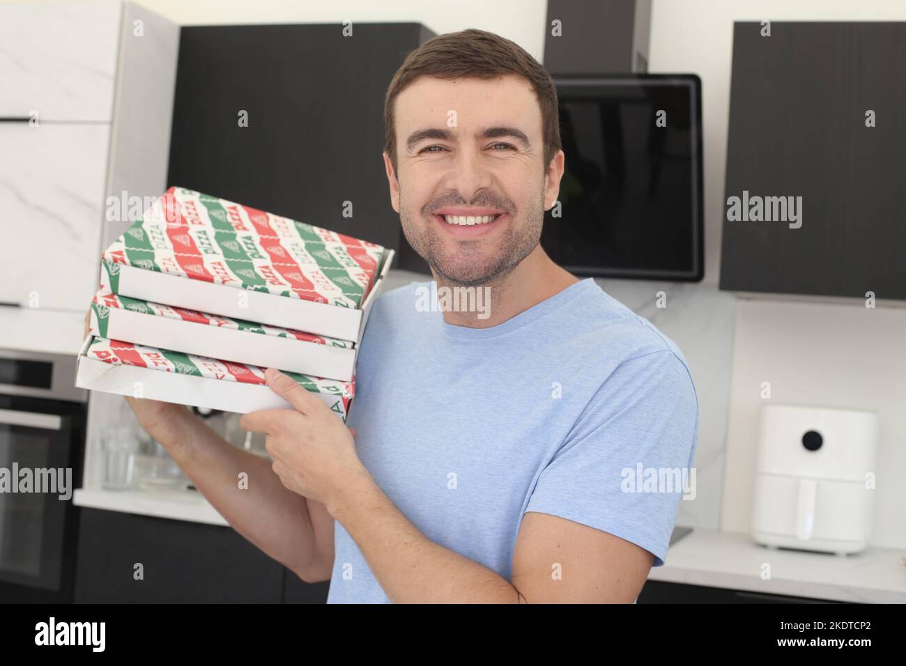 Mann, der zwei Pizzaboxen zu Hause hält Stockfoto