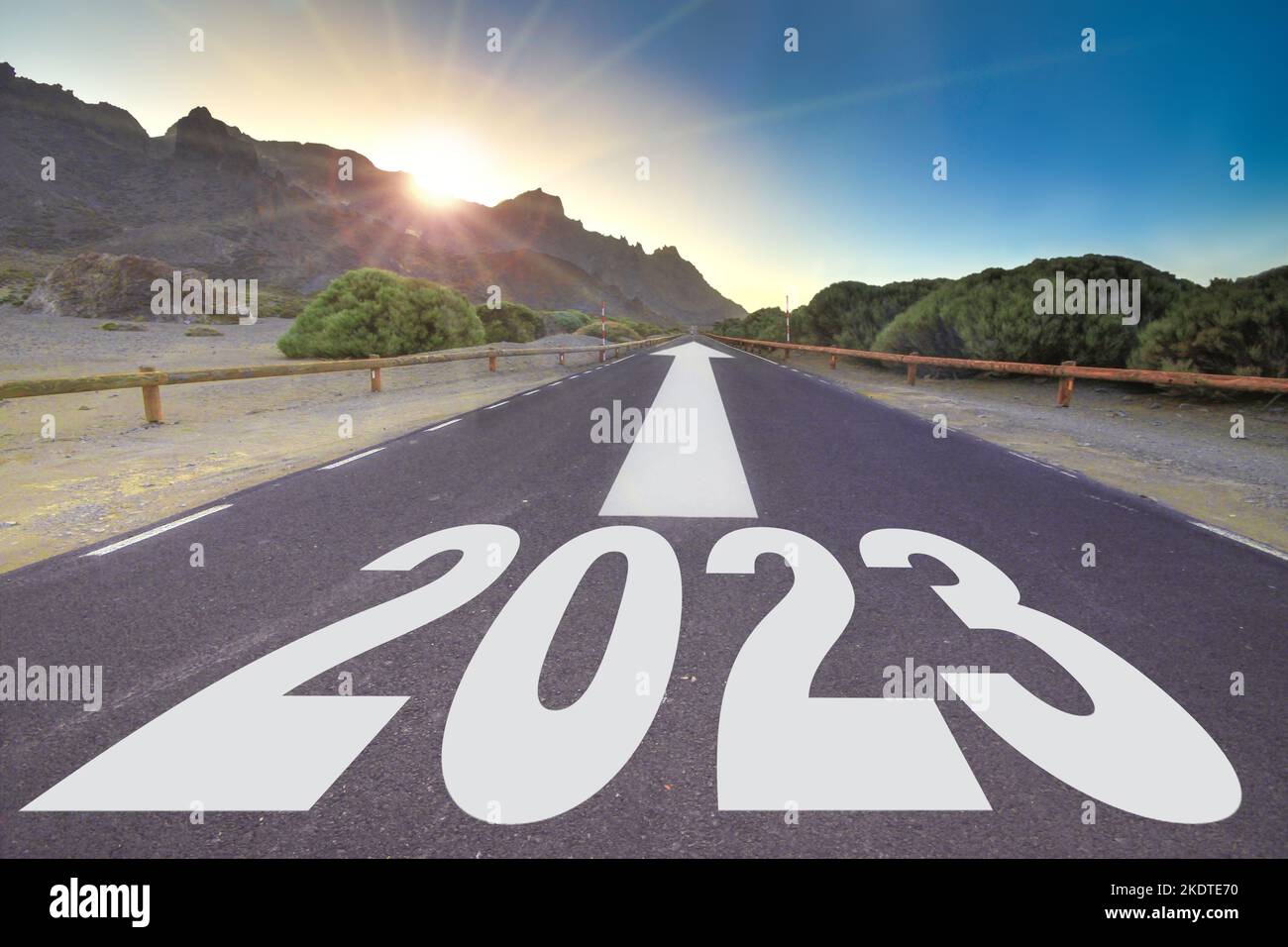 Neues Jahr 2023 Konzept, leere Asphaltstraße gegen den Sonnenaufgang mit Sonnenstrahlen Stockfoto