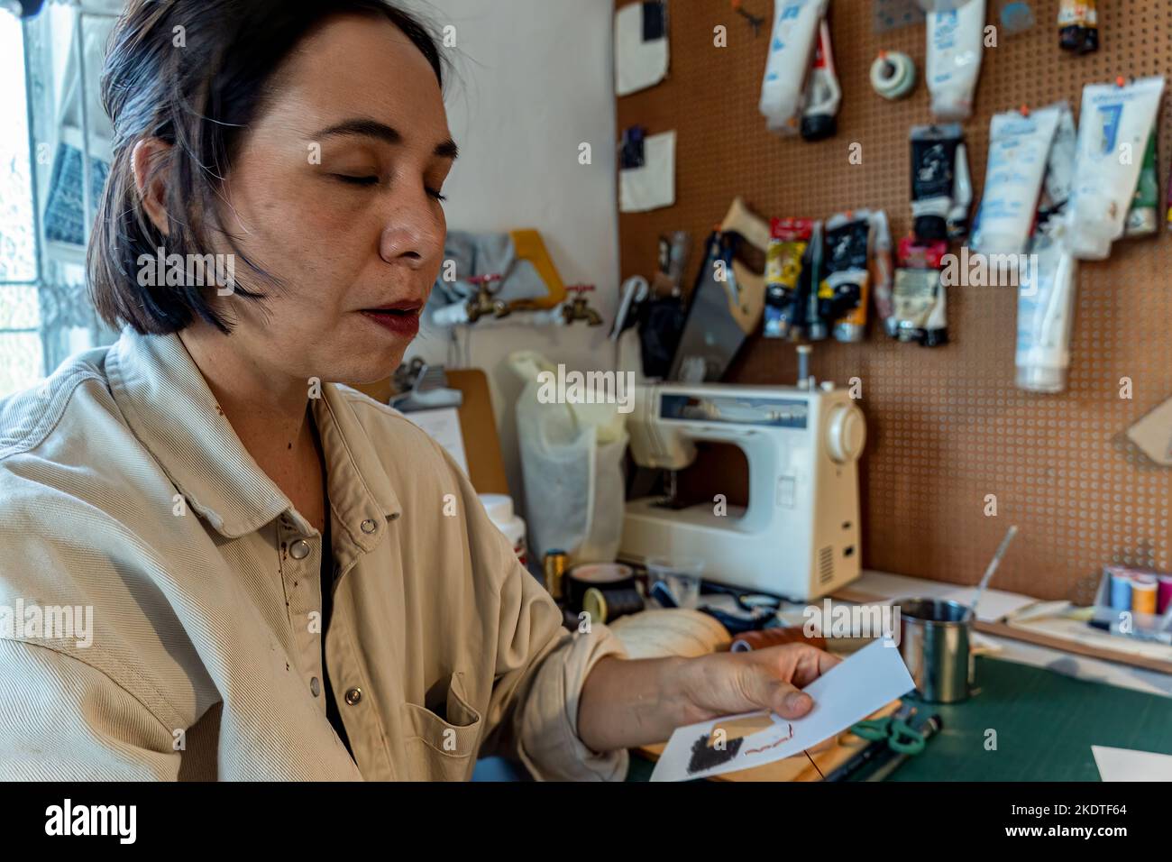 Die junge lateinerin, in ihrem eigenen Malstudio, kreiert Gemälde mit unterschiedlichen künstlerischen Techniken Stockfoto