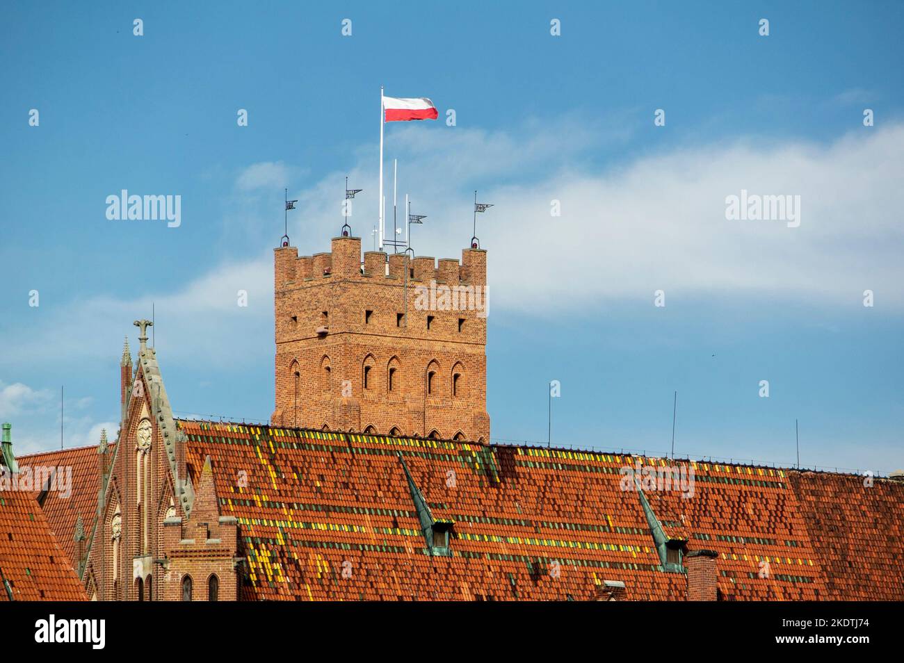 Polnische Flagge winkt auf einem Fahnenmast am Turm des Schlosses Malbork in Polen Stockfoto