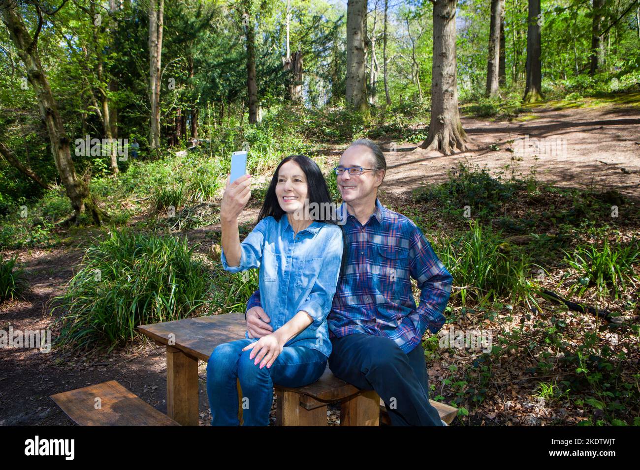 Ehepaar sitzt auf einer Bank im Wald Stockfoto