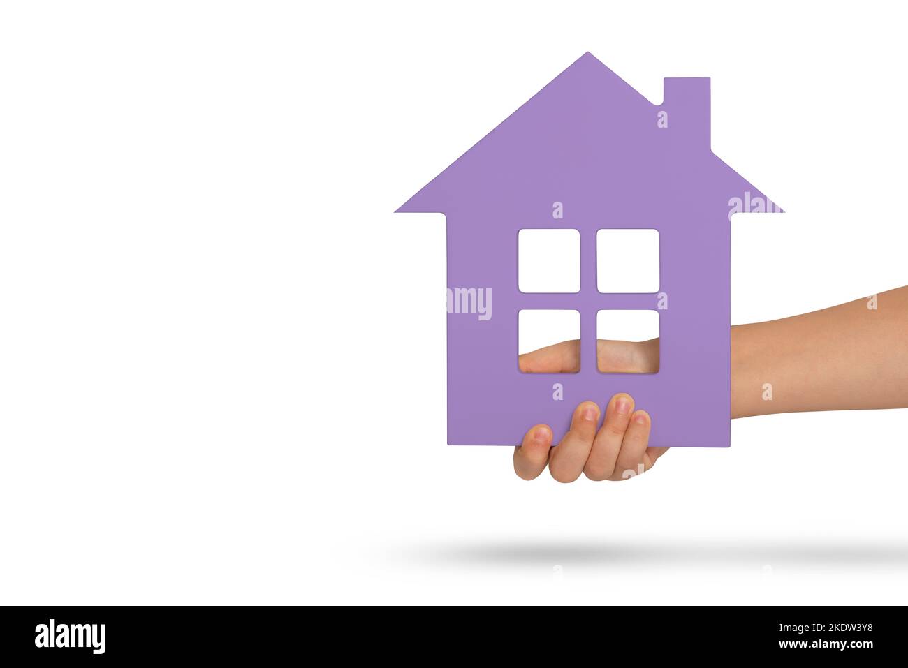 Haus in der Hand, Isolation. Violettes Modell eines Hauses in den Händen eines Kindes isoliert auf weißem Hintergrund. Obdachlosenheim, Familienhaus, Zuhause Stockfoto