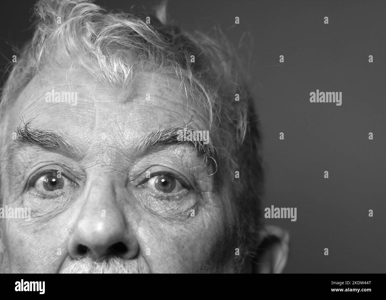 Ein verängstigter Blick auf einen gestressten und ängstigen alten Mann. Schwarz und Weiß. Stockfoto