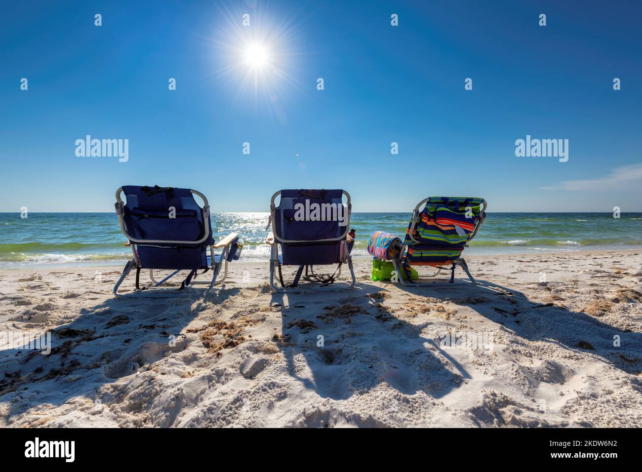 Sonniger tropischer Strand und Liegestühle in weißem Sand und Sonnenlicht Stockfoto