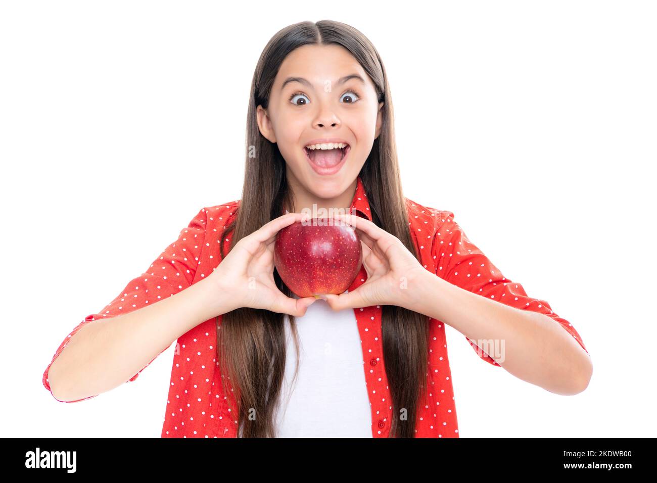 Kind Mädchen essen einen Apfel über isolierten weißen Hintergrund. Tennager mit Obst. Porträt der emotionalen erstaunt aufgeregt Teenager-Mädchen. Stockfoto