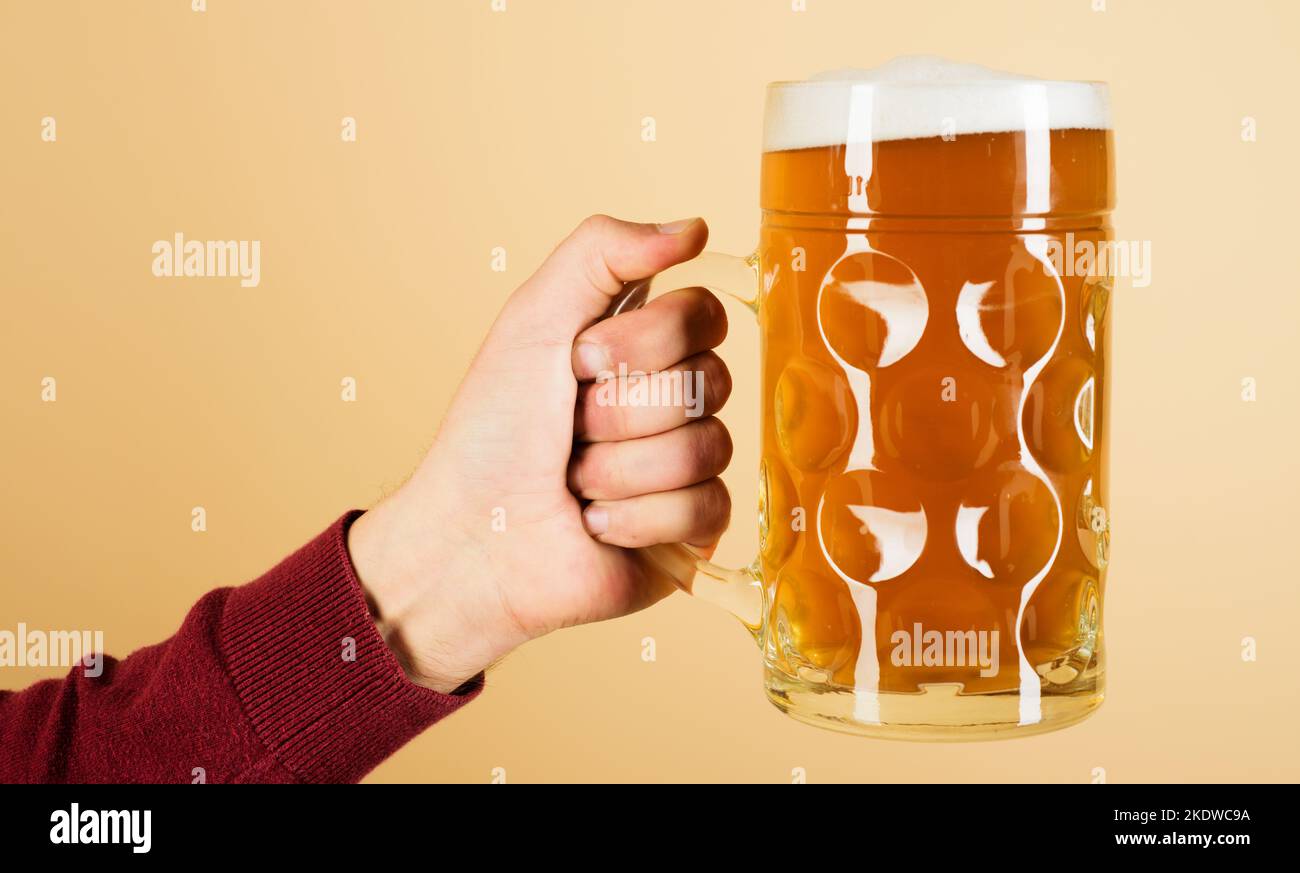 Mann Hand mit Becher Lagerbier. Oktoberfest-Getränk. Alkohol, Party, Degustation und Urlaubskonzept. Stockfoto