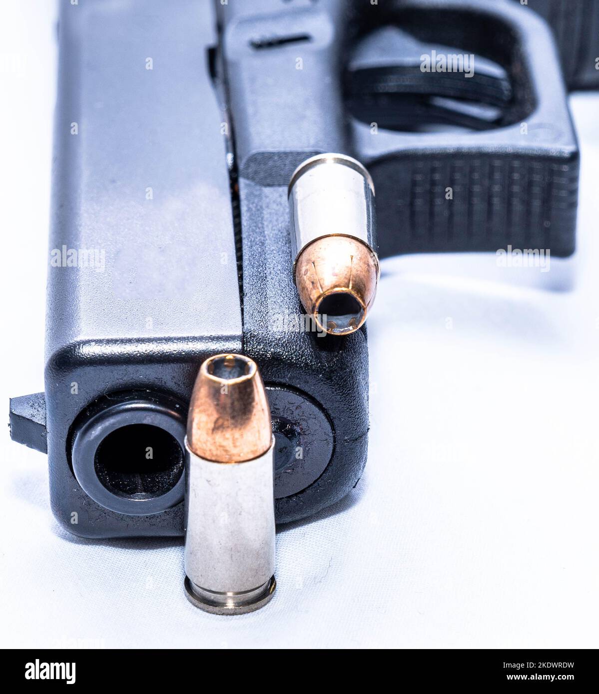 Eine schwarze Pistole aus dem Jahr 9mm mit zwei 9mm hohlen Punktekugeln auf weißem Hintergrund Stockfoto