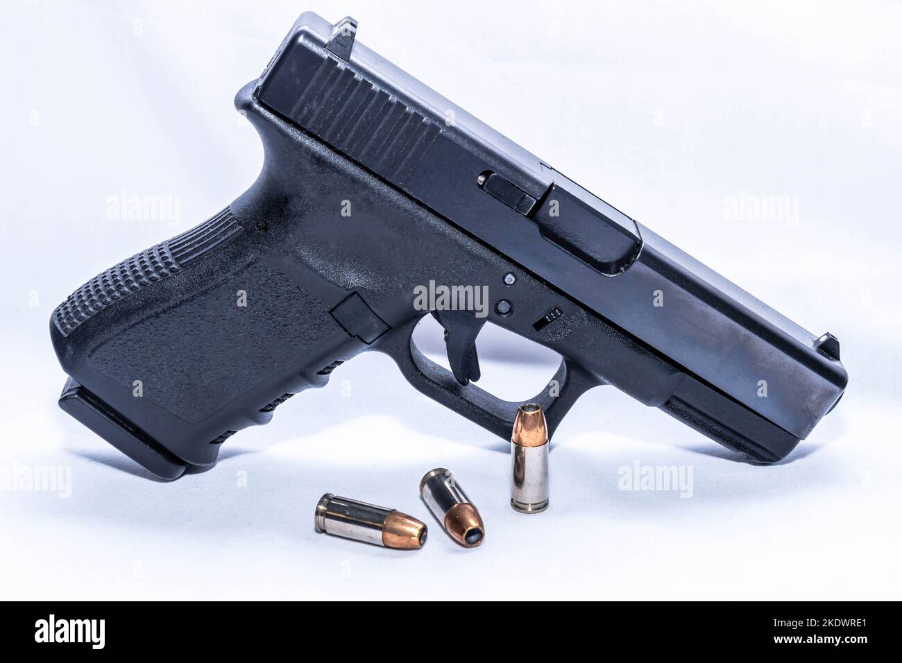 Eine schwarze Pistole aus dem Jahr 9mm mit drei 9mm hohlen Punktekugeln auf weißem Hintergrund Stockfoto