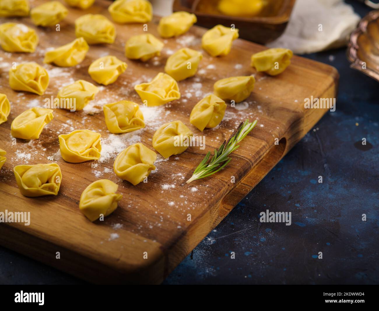Nahaufnahme. Hausgemachte Knödel, Ravioli auf einem Holzschneidebrett mit einem Zweig Rosmarin. Rezepte für Gerichte mit Hackfleisch. Restaurant, Hotel, Cate Stockfoto