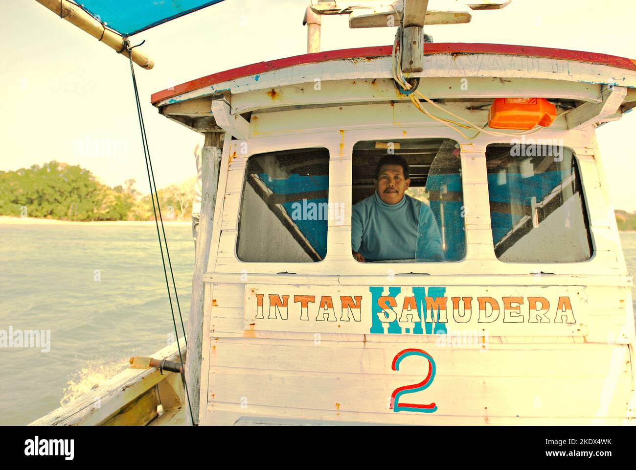 Ein Mann, der ein Boot steuert, das für einen Ausflug auf der Sunda-Straße im Ujung Kulon-Nationalpark in Pandeglang, Banten, Indonesien, gemietet wird. Stockfoto