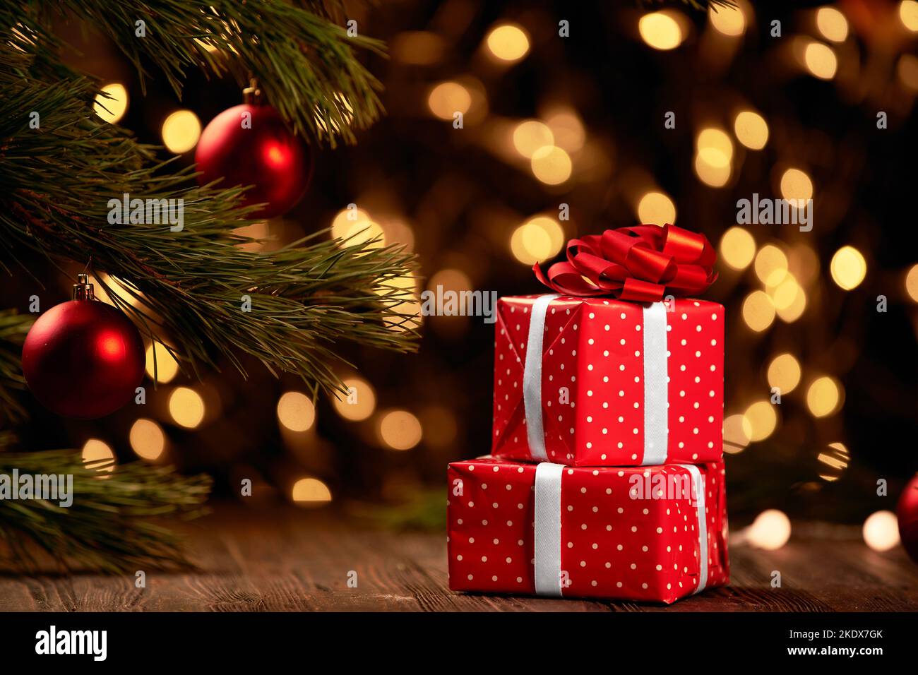 Rote Boxen mit Geschenken auf festlichem Weihnachtshintergrund. Stockfoto