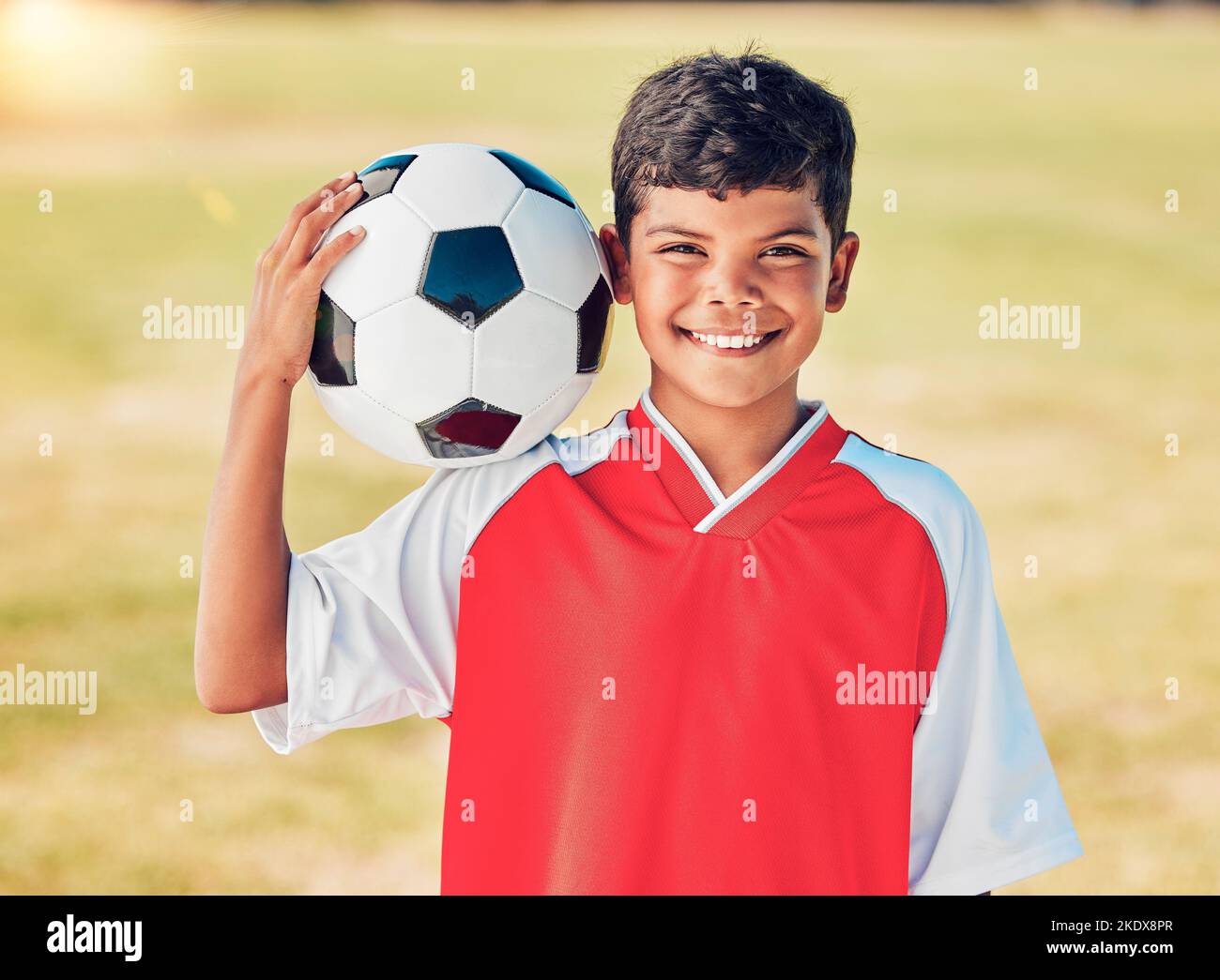 Boy Portrait, Feld und Fußball mit Lächeln für Sport, Fitness oder Training bei Fußballspiel, Wettbewerb oder Wettbewerb. Athlet Kind, Fußball und glücklich Stockfoto