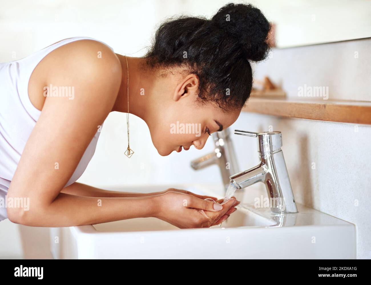 Halten Sie sich an eine Routine, die für Ihre Haut funktioniert. Eine junge Frau waschen ihr Gesicht im Badezimmer. Stockfoto